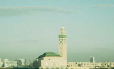 Exterior view of the Hassan II Mosque with the surrounding beach and Atlantic Ocean, a highlight of Morocco imperial cities tours