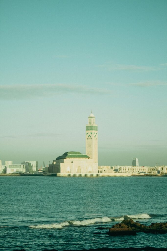 Exterior view of the Hassan II Mosque with the surrounding beach and Atlantic Ocean, a highlight of Morocco imperial cities tours