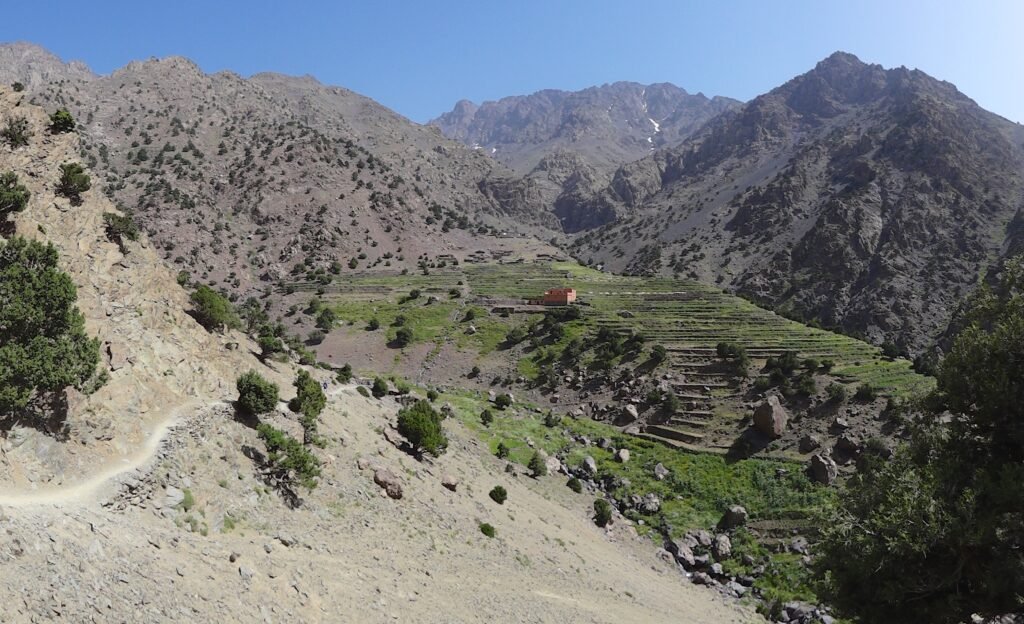 Hiking trail towards Refugio Azib Tamsoult passing through scenic landscapes and traditional Berber villages in the High Atlas Mountains of Morocco