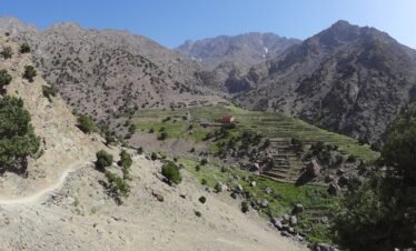 Hiking trail towards Refugio Azib Tamsoult passing through scenic landscapes and traditional Berber villages in the High Atlas Mountains of Morocco